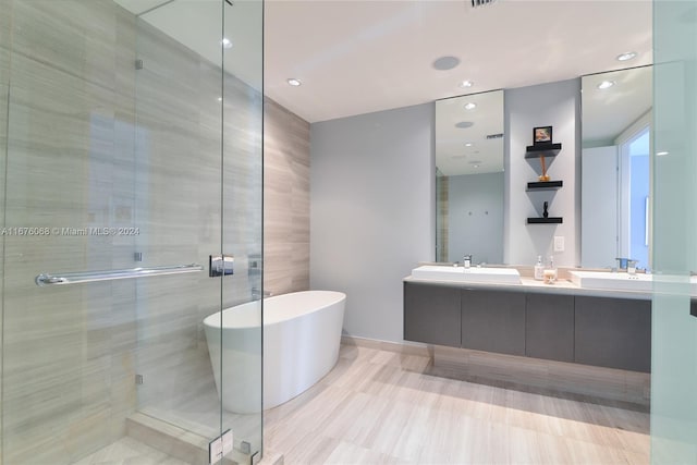 bathroom with vanity and shower with separate bathtub