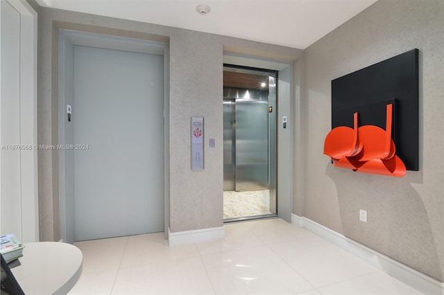 corridor featuring tile patterned floors and elevator