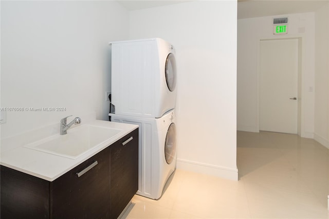 clothes washing area with sink and stacked washer / dryer