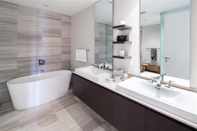 bathroom featuring tile walls, vanity, and a washtub