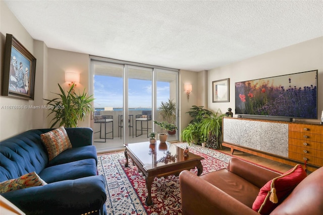 living room featuring a textured ceiling and a wall of windows