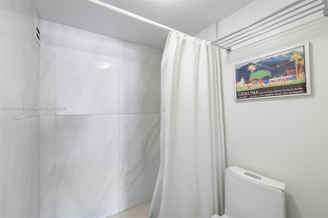 bathroom featuring toilet and a shower with shower curtain