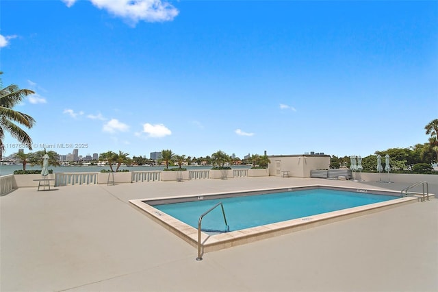 view of pool with a patio area and a water view