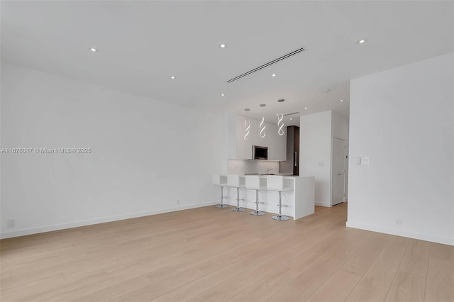 empty room with light hardwood / wood-style floors and a water view