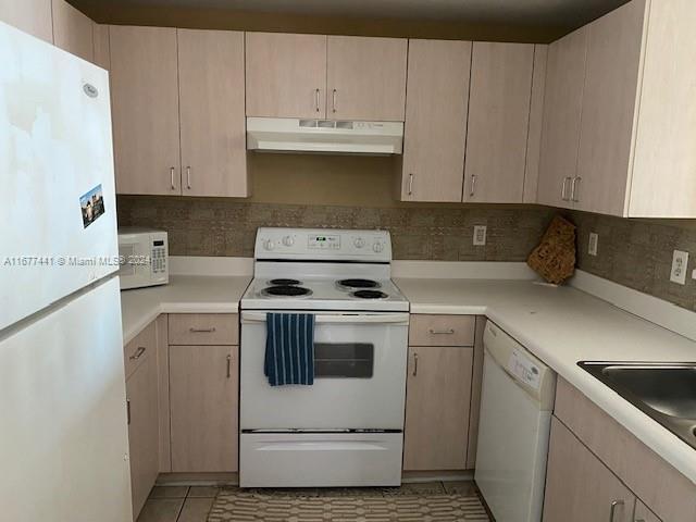 50 Menores Ave Unit 829, Coral Gables, FL 33134 - kitchen with under cabinet range hood, white appliances, light countertops, light tile patterned flooring, and backsplash