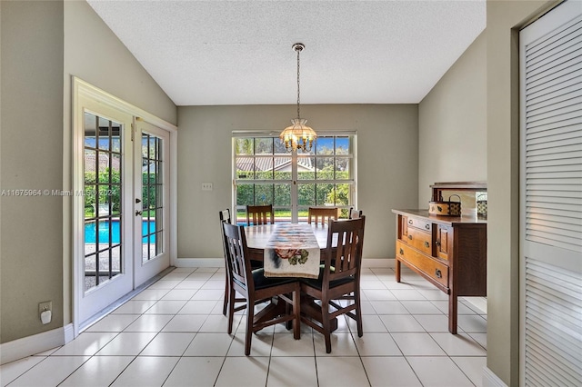 tiled dining area with french doors, a textured ceiling, vaulted ceiling, and an inviting chandelier