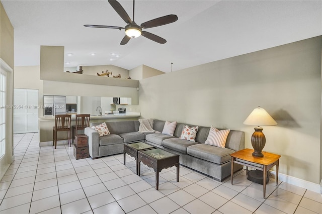 living room featuring lofted ceiling, sink, light tile patterned floors, and ceiling fan