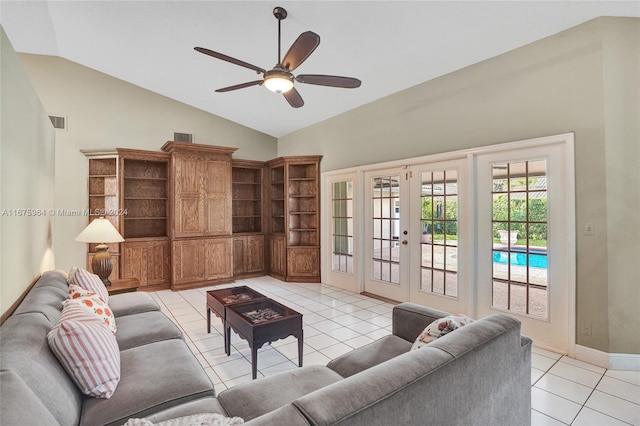 tiled living room with ceiling fan, high vaulted ceiling, and french doors