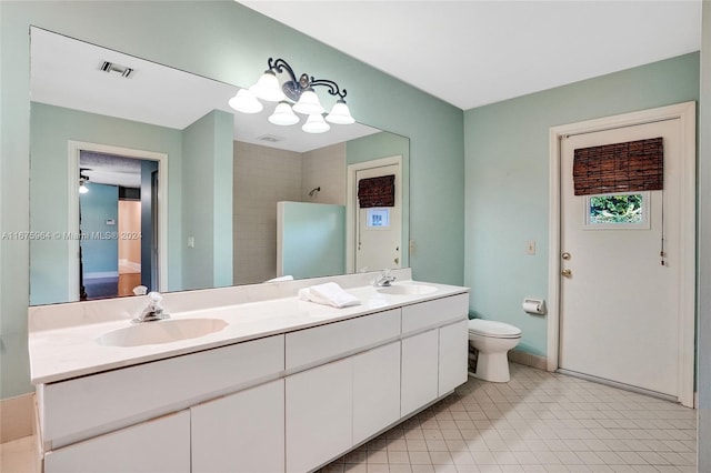 bathroom featuring toilet, vanity, and a tile shower