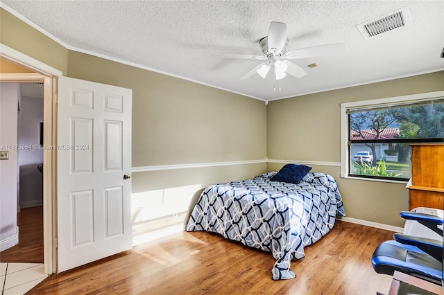 bedroom featuring a textured ceiling, hardwood / wood-style floors, and ceiling fan