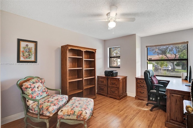 office space with light hardwood / wood-style flooring, a textured ceiling, and ceiling fan