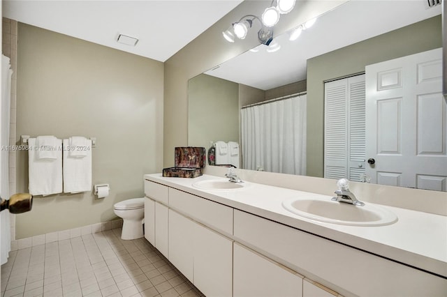 bathroom featuring vanity, tile patterned floors, and toilet