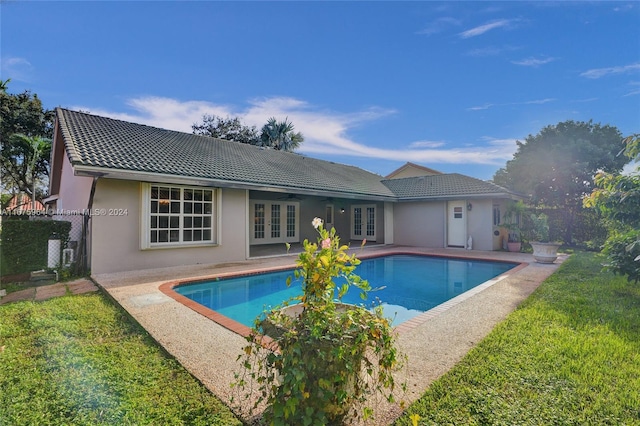 view of swimming pool with french doors, a lawn, and a patio area