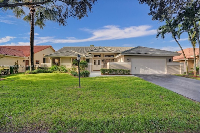 mediterranean / spanish home featuring a front lawn and a garage