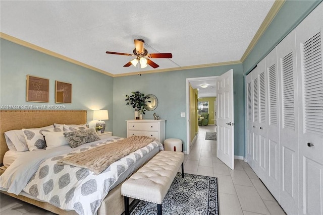 tiled bedroom with ceiling fan, a closet, a textured ceiling, and ornamental molding