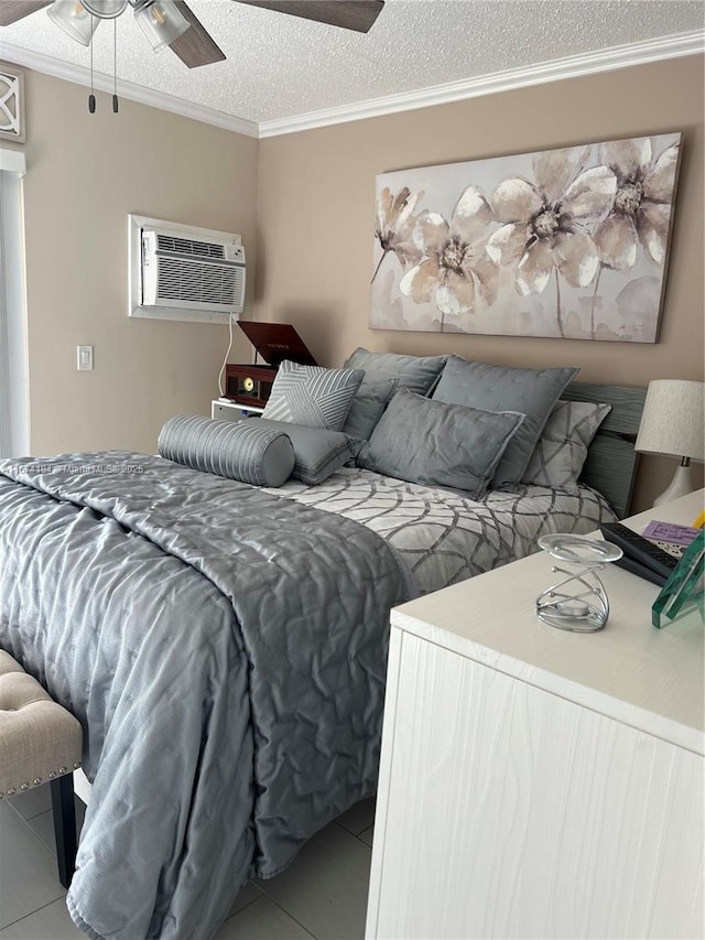 tiled bedroom with an AC wall unit, ceiling fan, a textured ceiling, and ornamental molding