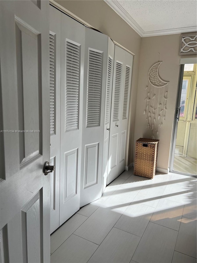 interior space featuring a textured ceiling, ornamental molding, and light tile patterned flooring