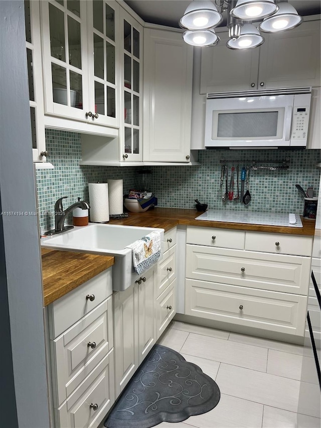 kitchen with white cabinets, decorative backsplash, and light tile patterned floors