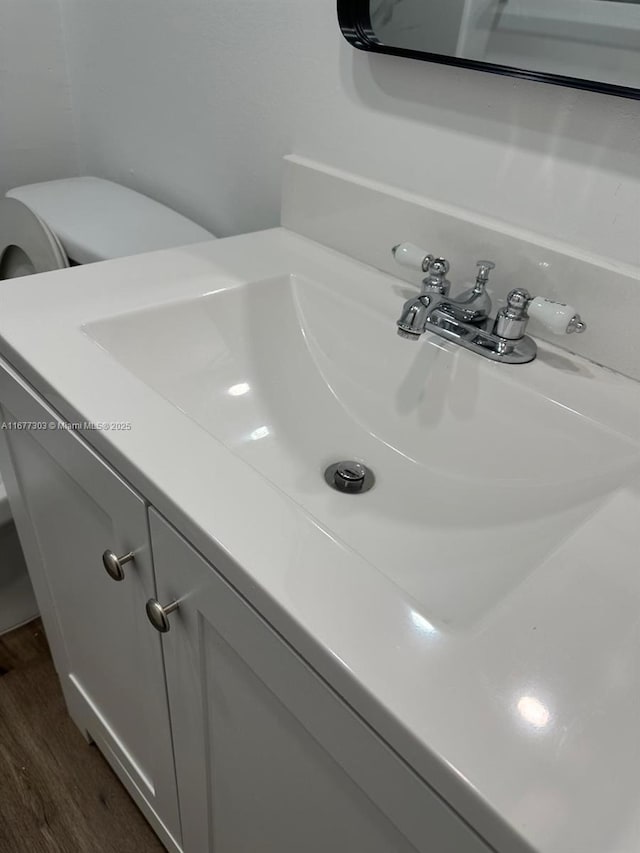 bathroom featuring toilet, vanity, and wood-type flooring