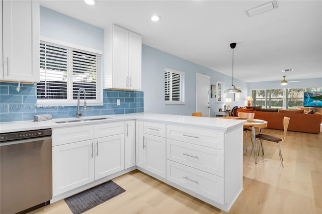 kitchen featuring dishwasher, sink, decorative light fixtures, white cabinets, and light hardwood / wood-style floors