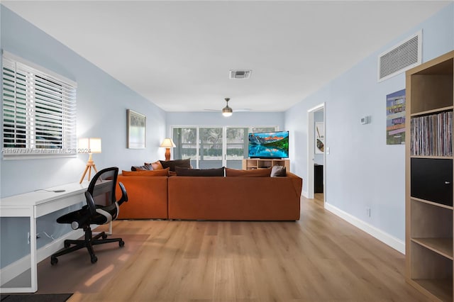 living room with light hardwood / wood-style flooring and ceiling fan