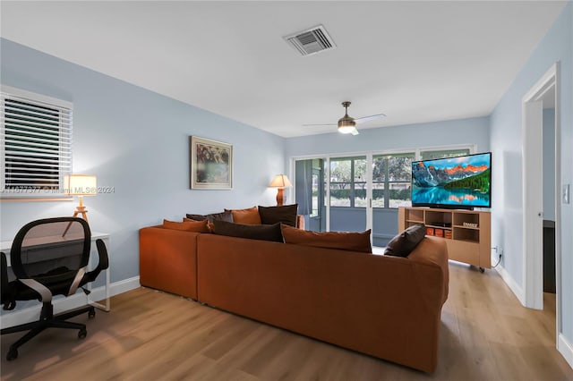 living room with light hardwood / wood-style floors and ceiling fan