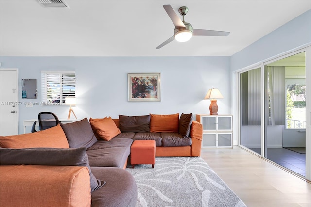 living room with light hardwood / wood-style flooring, a healthy amount of sunlight, and ceiling fan