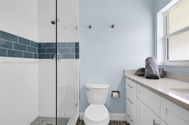 bathroom featuring vanity, toilet, hardwood / wood-style flooring, and an enclosed shower