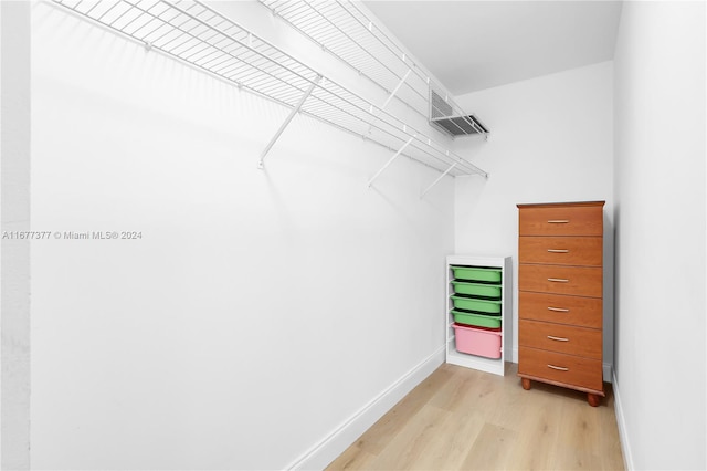 walk in closet with light wood-type flooring