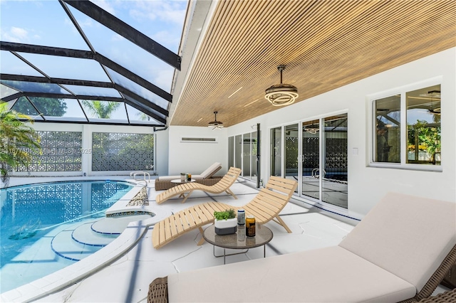 view of patio / terrace with ceiling fan, a swimming pool with hot tub, and a lanai