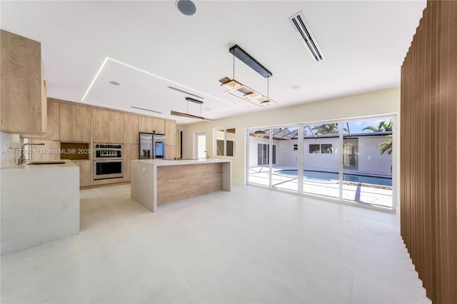 kitchen with pendant lighting, sink, kitchen peninsula, and appliances with stainless steel finishes