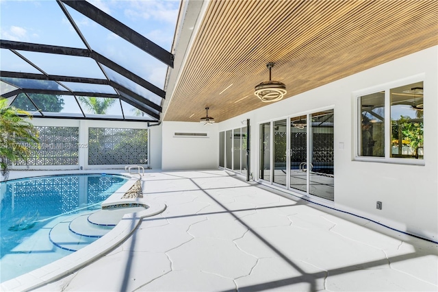 view of swimming pool featuring a patio area, an in ground hot tub, ceiling fan, and glass enclosure