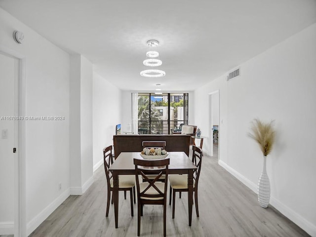 dining space featuring light hardwood / wood-style floors and a notable chandelier