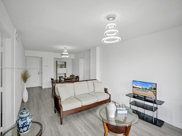 living room featuring a notable chandelier and light wood-type flooring