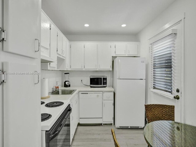 20400 W Country Club Dr Unit 301, Aventura, FL 33180 - kitchen featuring white appliances, a sink, white cabinetry, light countertops, and light wood-style flooring