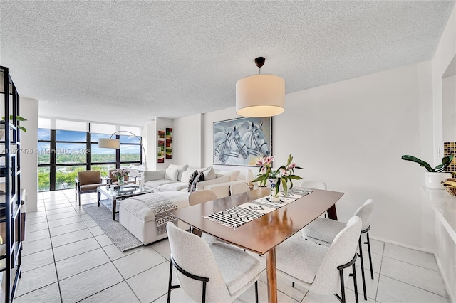 tiled dining area featuring a textured ceiling and floor to ceiling windows