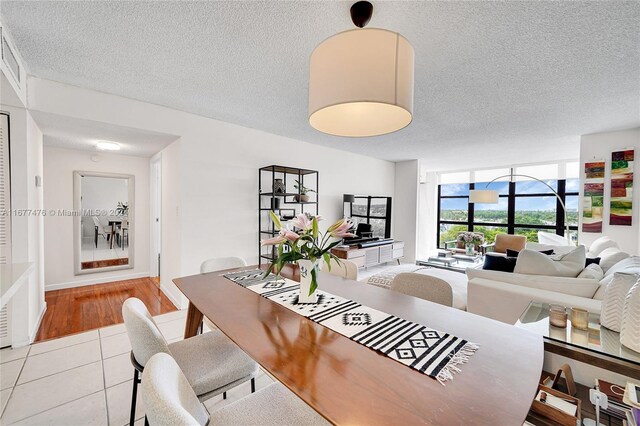 dining area with light hardwood / wood-style flooring and a textured ceiling