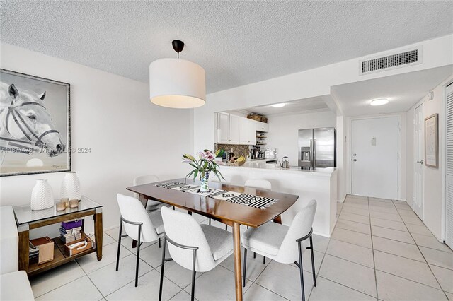 dining room featuring a textured ceiling and light tile patterned floors