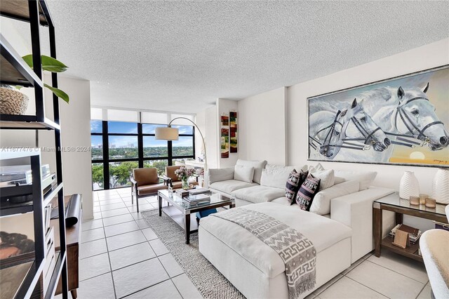 tiled living room featuring a wall of windows and a textured ceiling