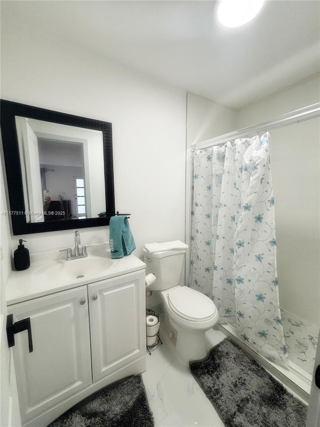 bathroom featuring vanity, toilet, and walk in shower