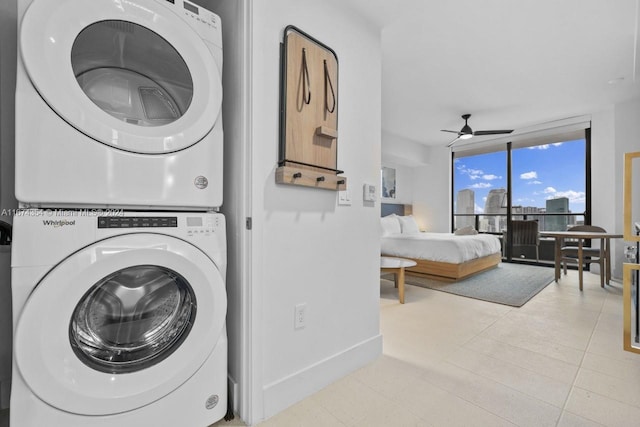 laundry area with stacked washer and clothes dryer, light tile patterned floors, and ceiling fan