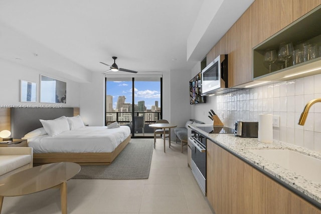 tiled bedroom featuring ceiling fan, sink, and access to exterior