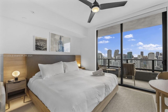 bedroom featuring access to outside, ceiling fan, and expansive windows