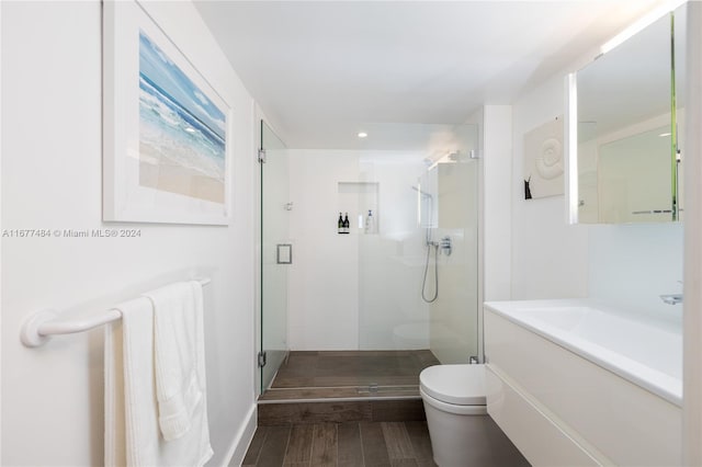 full bath featuring recessed lighting, a shower stall, vanity, toilet, and wood finished floors