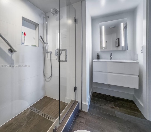 full bathroom featuring a stall shower, wood finished floors, and vanity