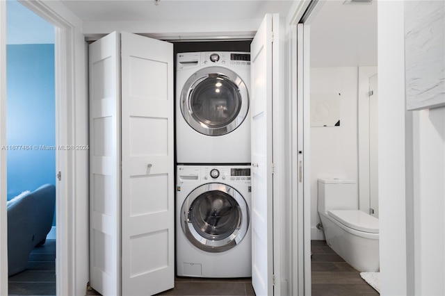 clothes washing area with stacked washer / drying machine and dark hardwood / wood-style flooring