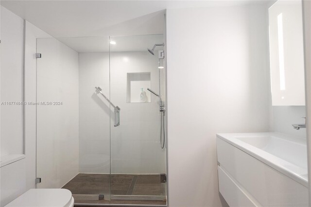 bathroom featuring recessed lighting, a shower stall, toilet, and a sink