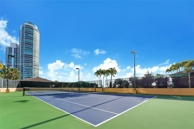 view of tennis court featuring fence and community basketball court