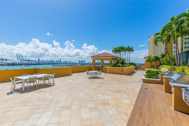 view of patio with a gazebo, outdoor dining space, area for grilling, and a city view