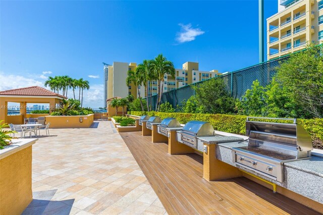 exterior space with outdoor dining space, an outdoor kitchen, and fence